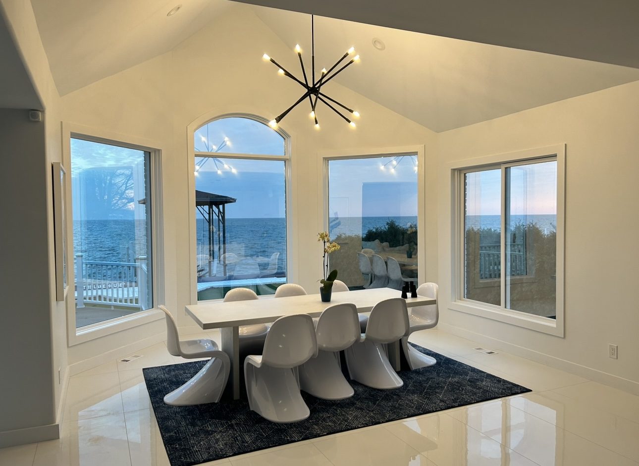 Renovated waterfront dining room with vaulted ceiling and custom lighting, whole-home remodel by Mount Vernon Construction